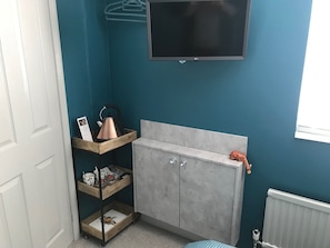 Enjoy a compact room with a flat-screen TV, cabinet, and shelf unit.