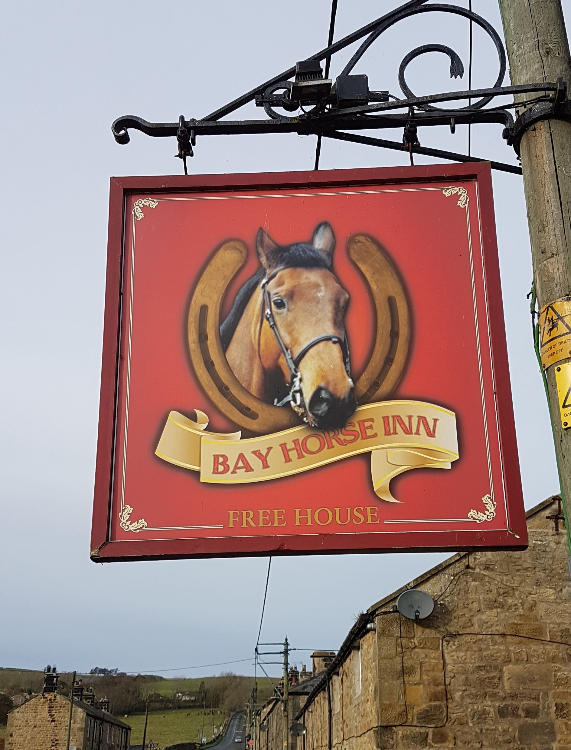 A red sign with a horse's head and the text "Bay Horse Inn Free House".