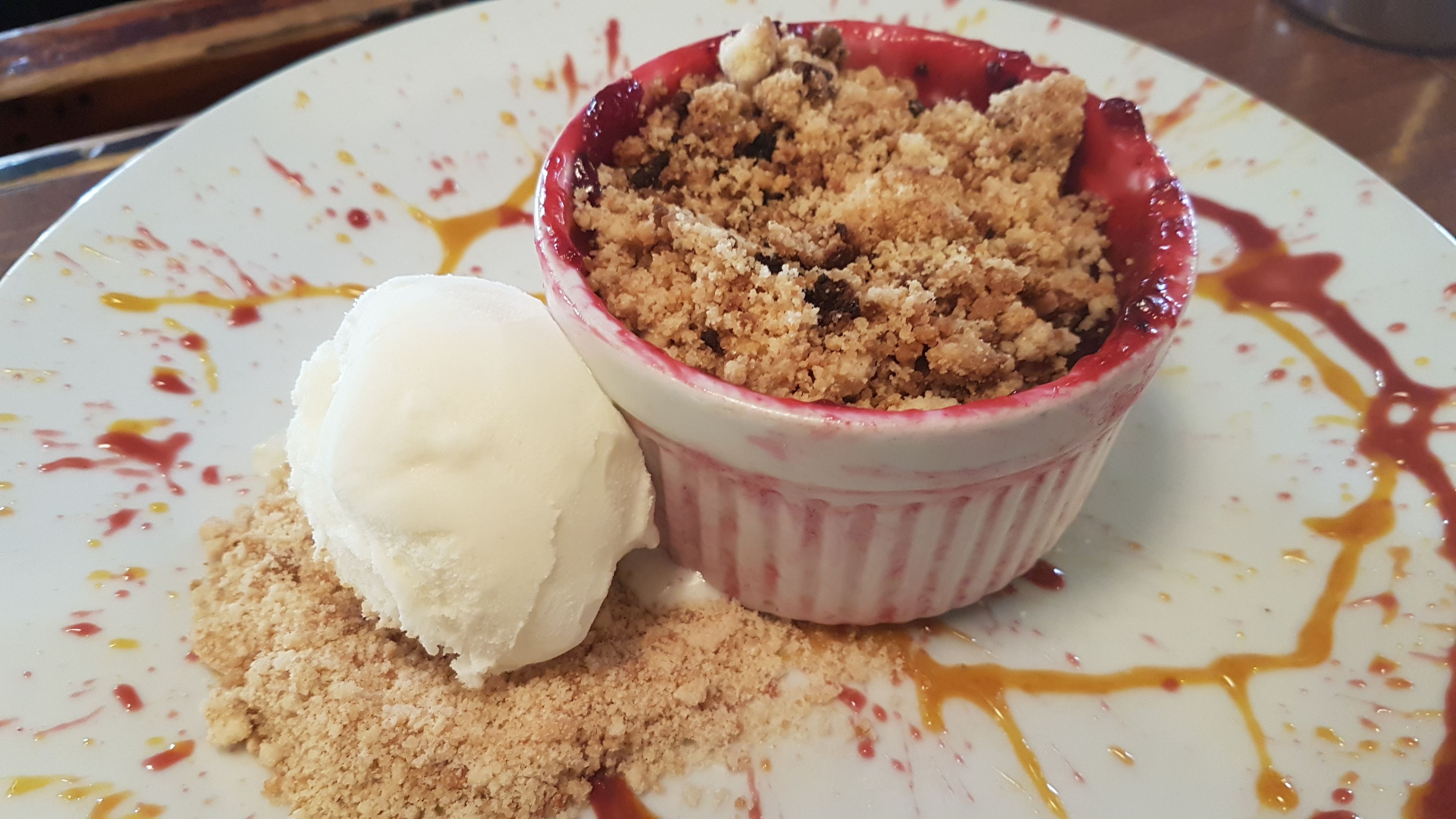 Un dessert composé d’une pâte à crumble et d’une boule de glace, le tout servi dans une assiette.