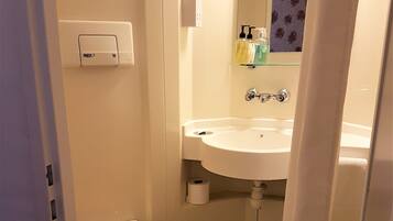 A small bathroom with a wooden toilet, a white sink, and a mirror above it.