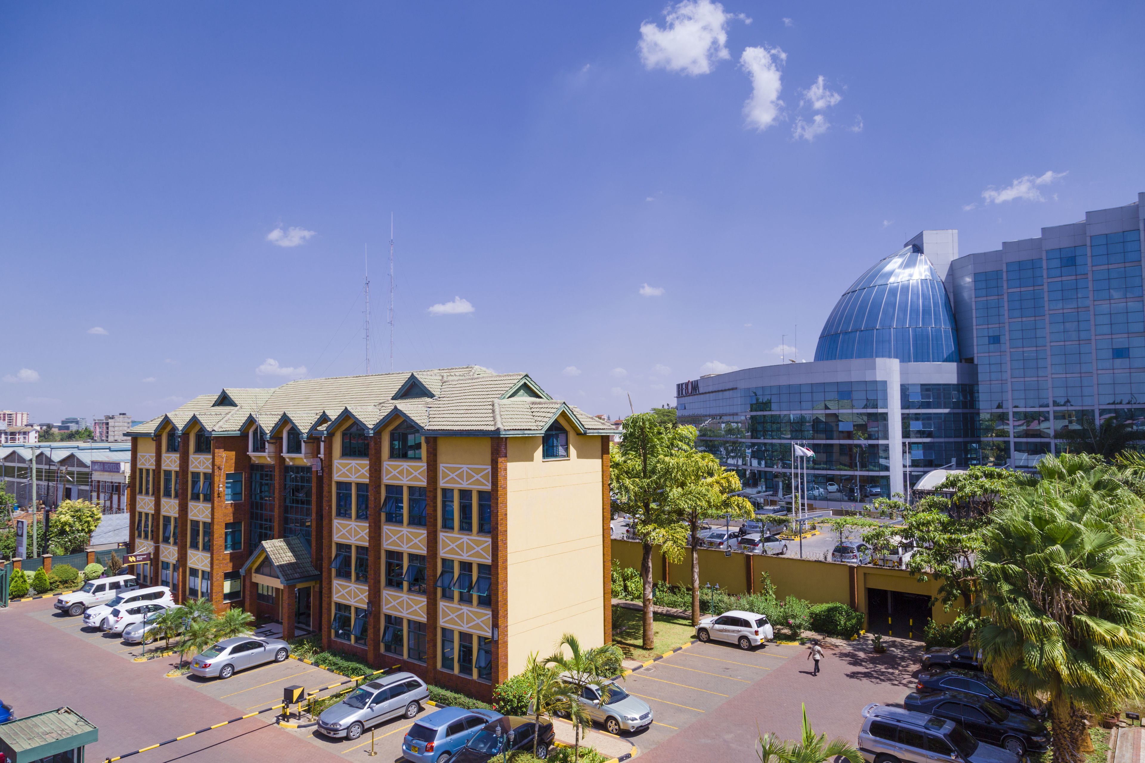 A multi-story building with a parking lot in front, featuring a mix of modern and traditional architectural styles.