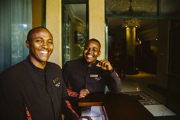 Twee personen staan in een hotel lobby met een kroonluchter en een kamerbreed tapijt.