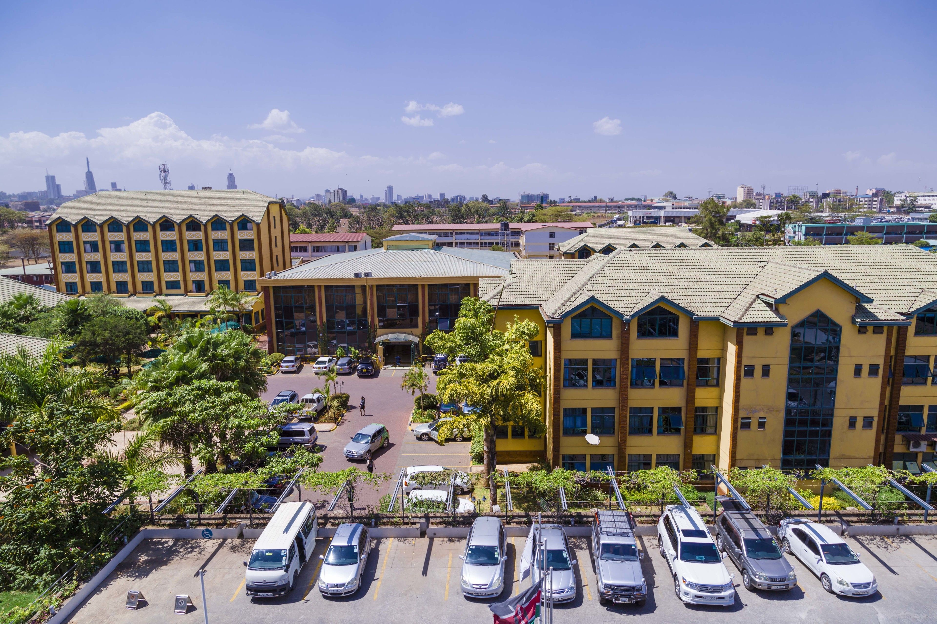 A multi-story building with a parking lot in front.