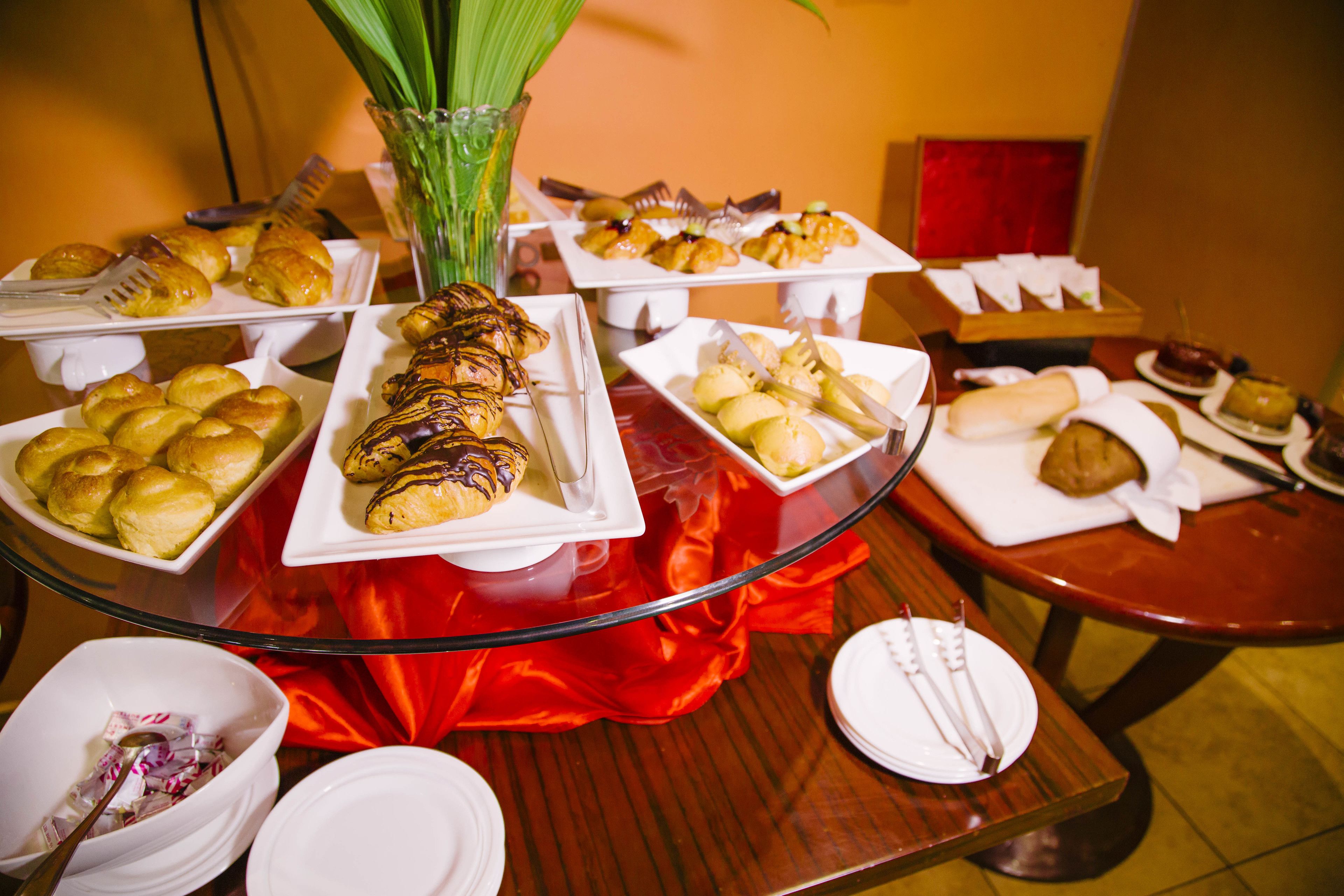 A buffet table with various food items and utensils.