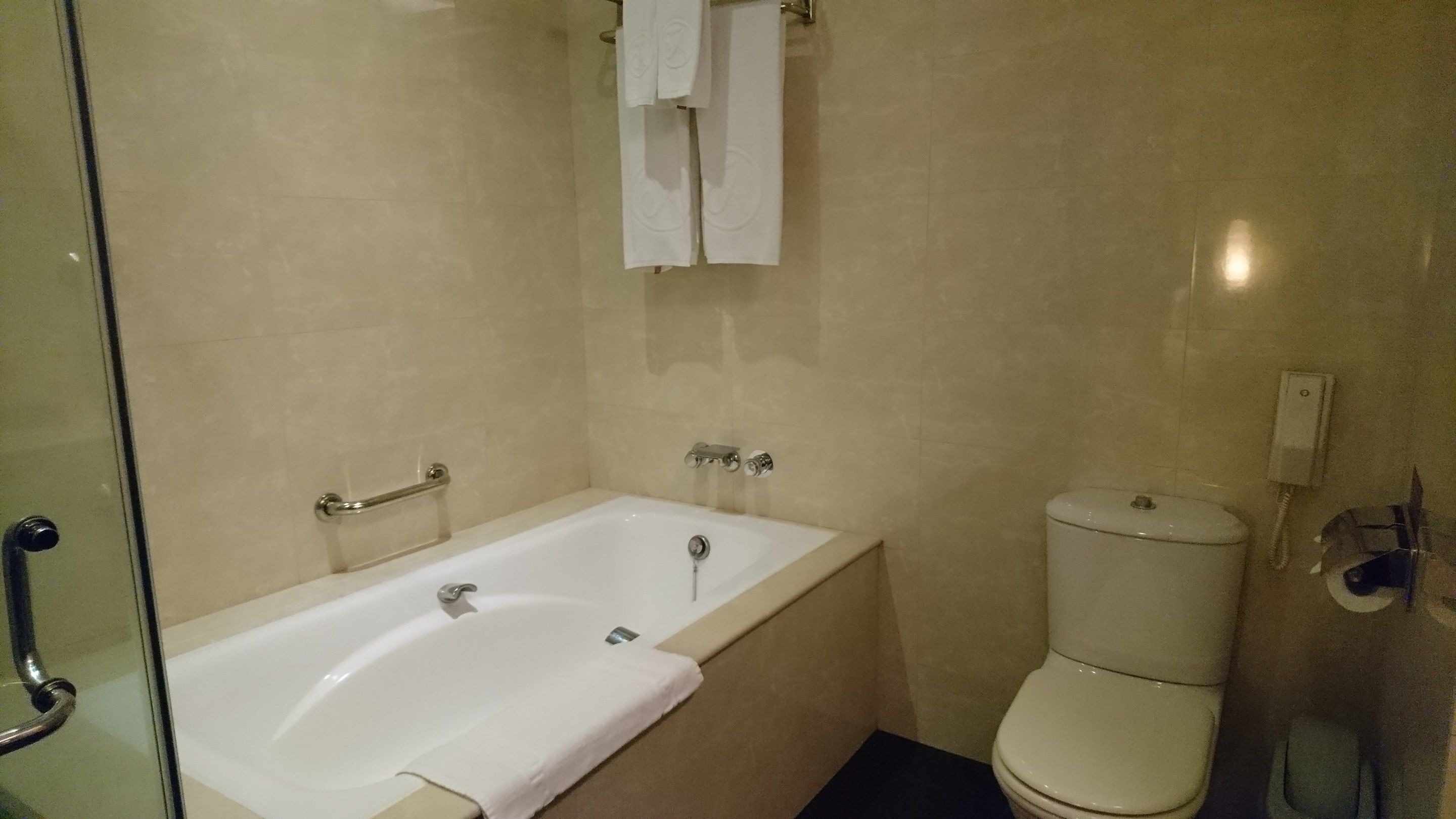 A bathroom with a bathtub, toilet, and a glass shower enclosure.