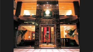 The entrance of a hotel with a glass door, a sign above the door, and a reception desk inside. - Taipei International Hotel (Taipei)
