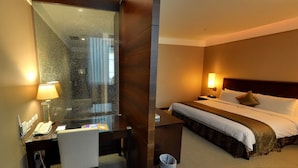 A hotel room with a desk, chair, and a bed with pillows and a blanket. - Taipei International Hotel (Taipei)