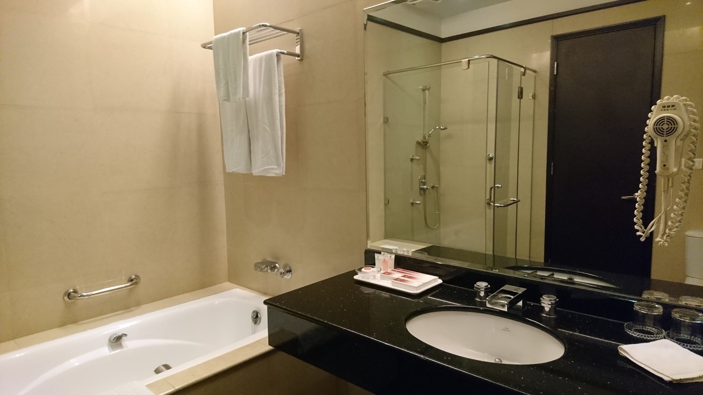 A bathroom with a bathtub, a sink, a mirror, and a shower.