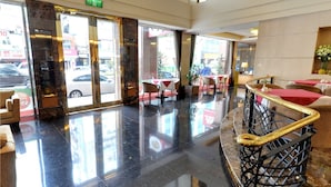A hotel lobby with a marble floor, a staircase with golden railings, and tables with red tablecloths. - Taipei International Hotel (Taipei)