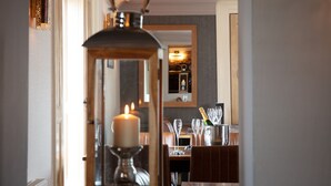 A candle-lit table with a bottle of champagne, glasses, and a mirror reflecting a cozy interior. - Broom Hall Inn (Alcester)