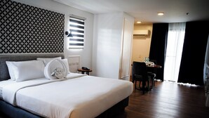 Una habitación de hotel con una cama grande, un escritorio y una silla.