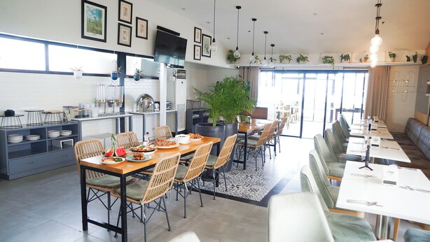 Un comedor moderno con una mesa larga, sillas y una zona de bar.