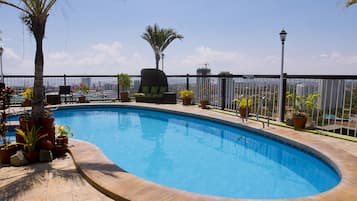 Una piscina al aire libre, sillones reclinables de piscina