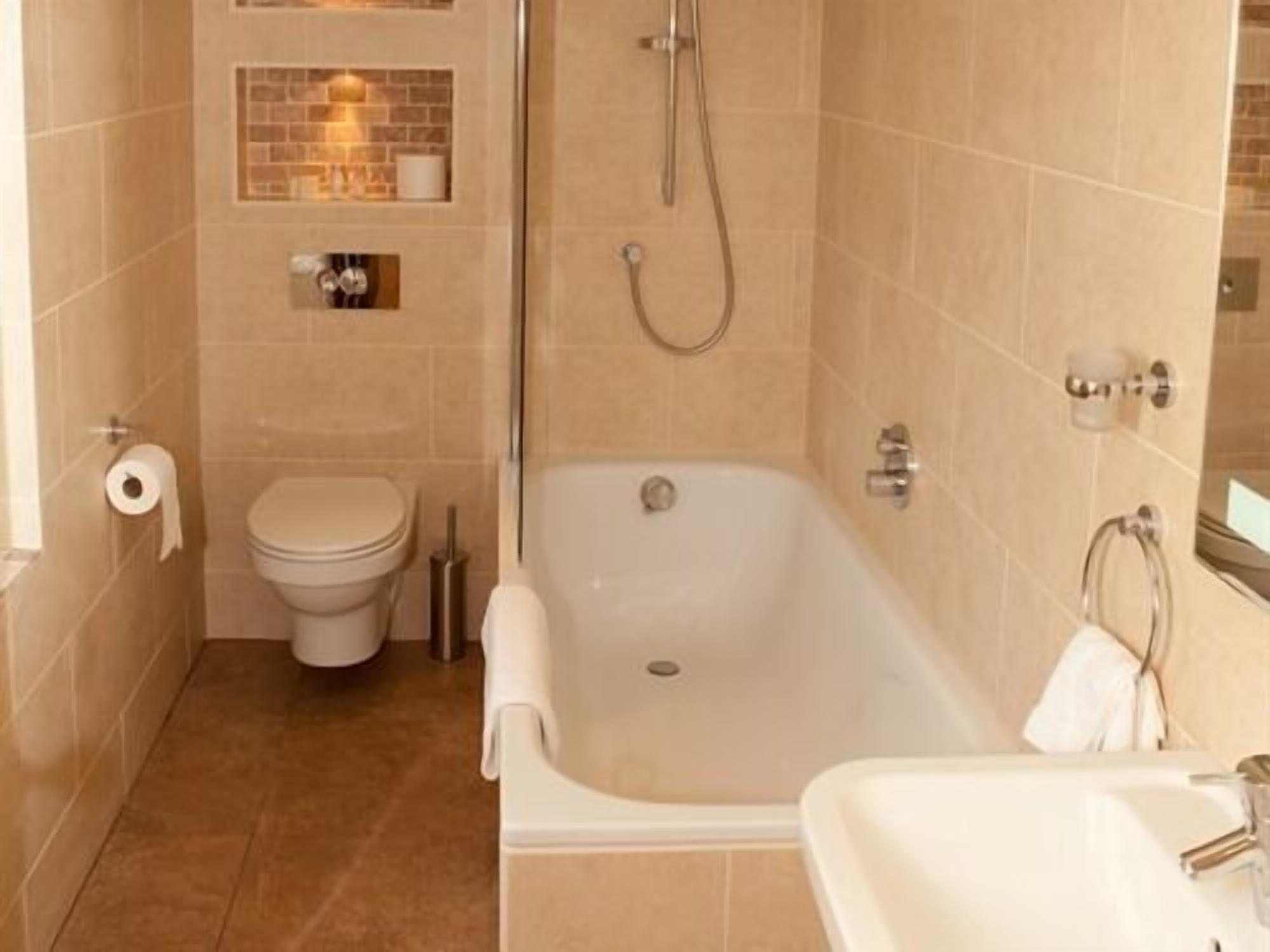 Un baño con bañera, inodoro y lavamanos.