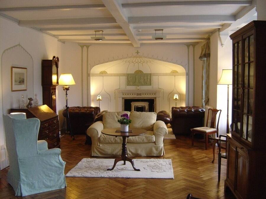 Una sala de estar tradicional con chimenea, dos sofás, una mesita y un sillón azul.