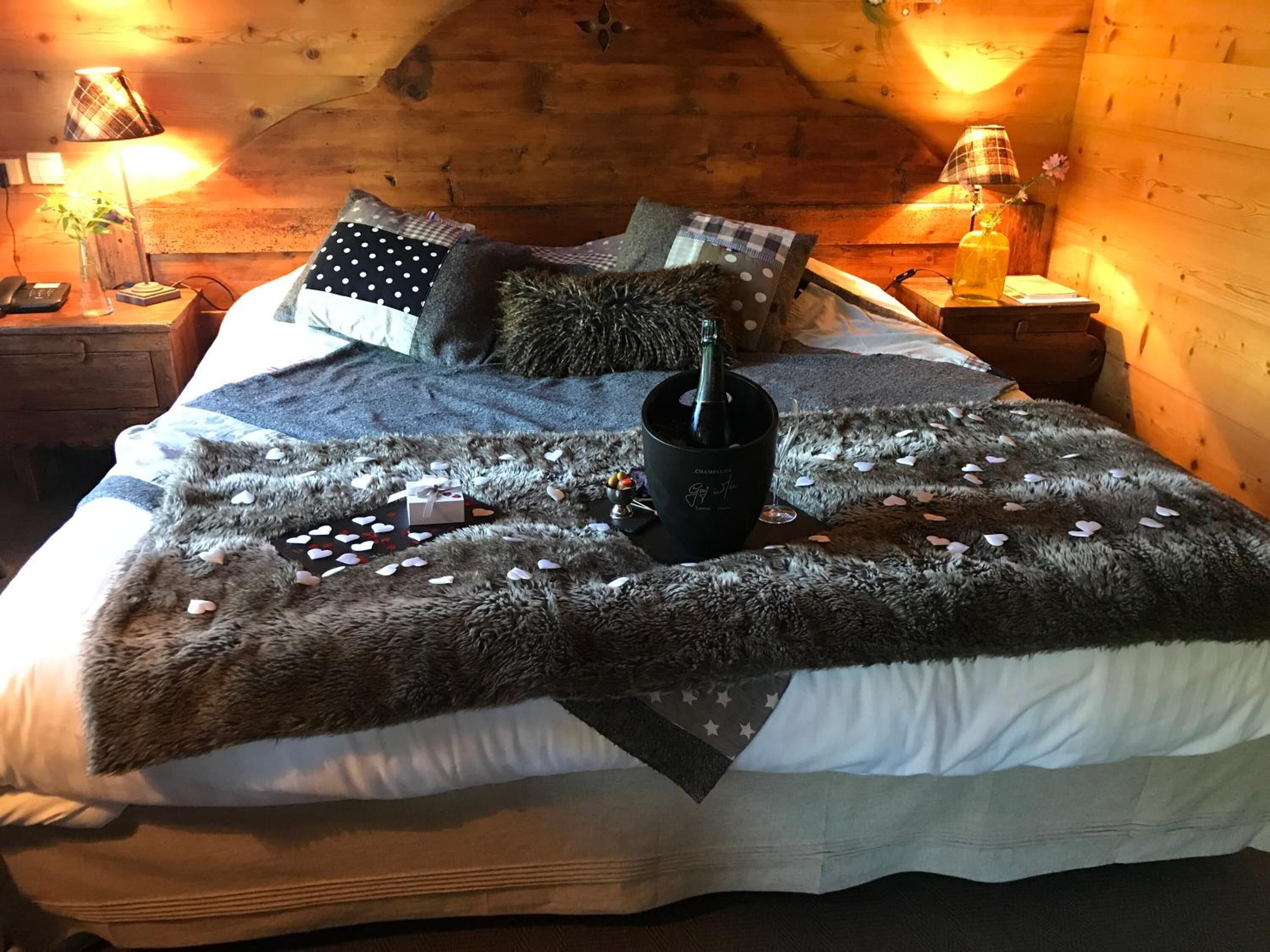 Ein gemütliches Zimmer mit einem Bett, einem Nachttisch mit Lampe und einem kleinen Tisch mit einer Vase.