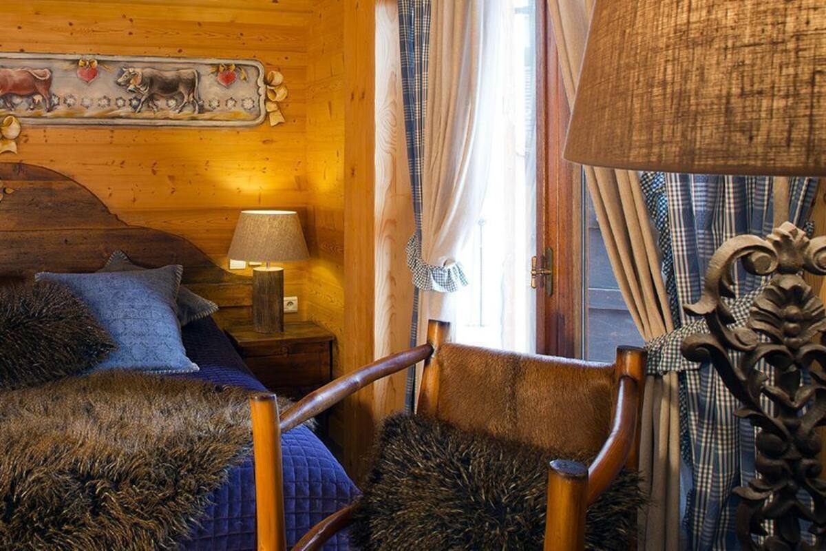 Una habitación acogedora de madera con cama, dos lámparas de noche y un cabecero decorativo.