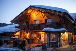 Un hôtel en bois, sur lequel on peut lire l’inscription : « Hôtel Chalet Les Cimes ».