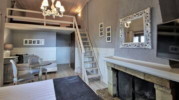 Un dormitorio con una cama litera, chimenea, televisor y candelabro.