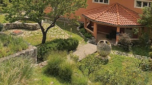 Una casa con techo de tejas rojas, un sendero de piedra y vistas a un lago.