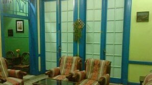 A room with striped armchairs, a glass coffee table, and a green wall with blue trim. - Richmond Hotel (Cairo)
