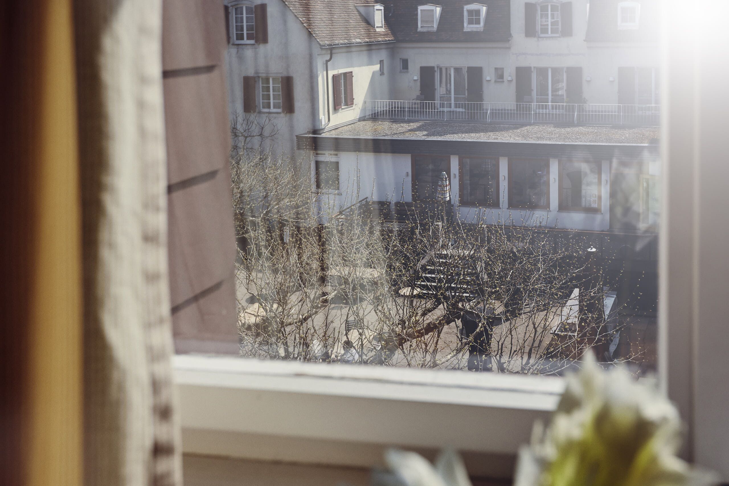 A view from a window overlooking a residential area with buildings and bare trees.