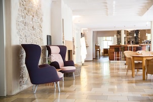 Un salón amplio con pared de piedra, muebles modernos y una mesa de comedor de madera.