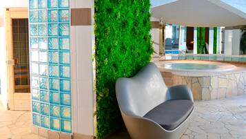 Relax in a serene outdoor space with a seating area, lush greenery, and a pool.