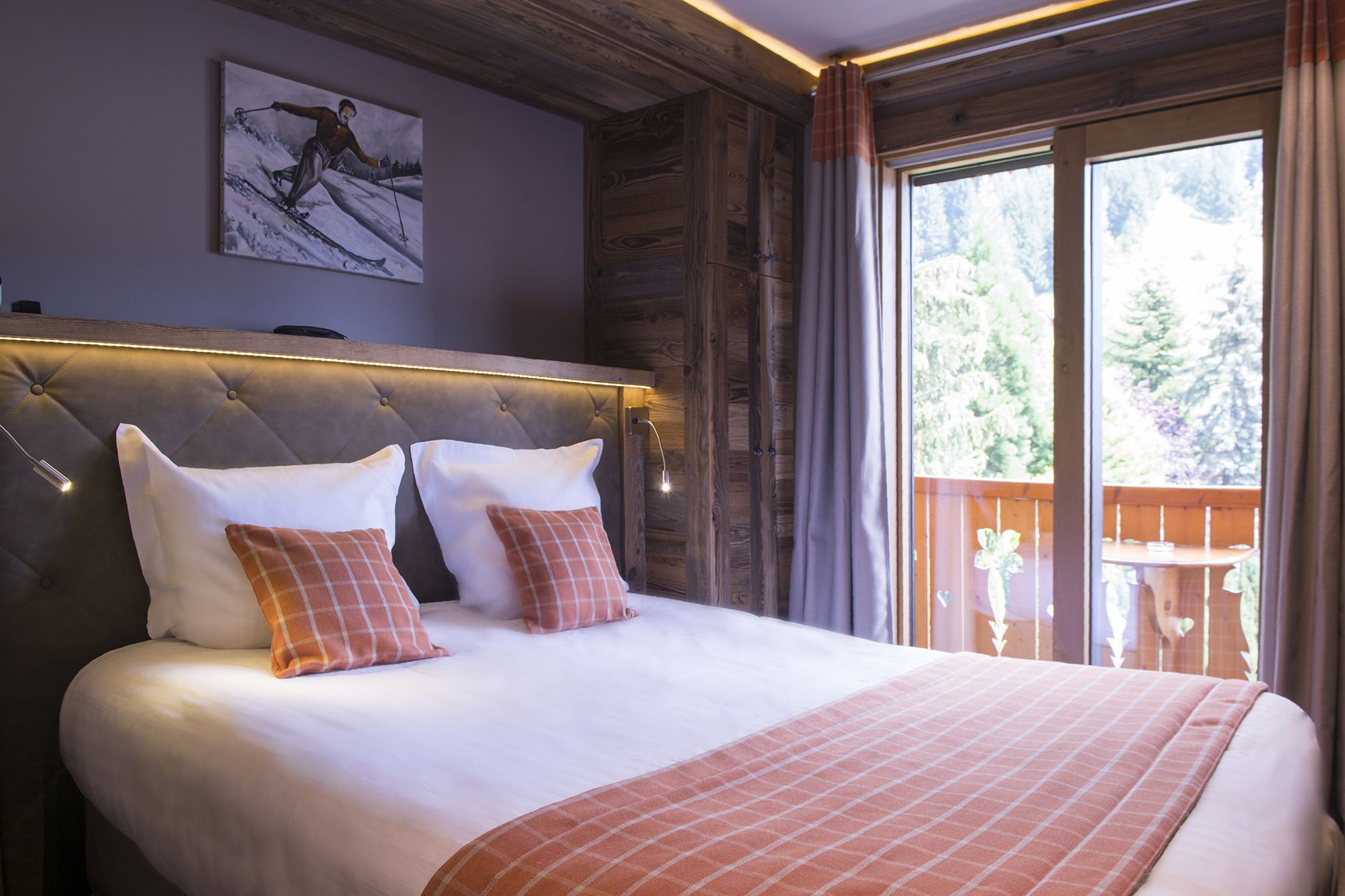 A bed with a tufted headboard, white and plaid pillows, and a checkered blanket.
