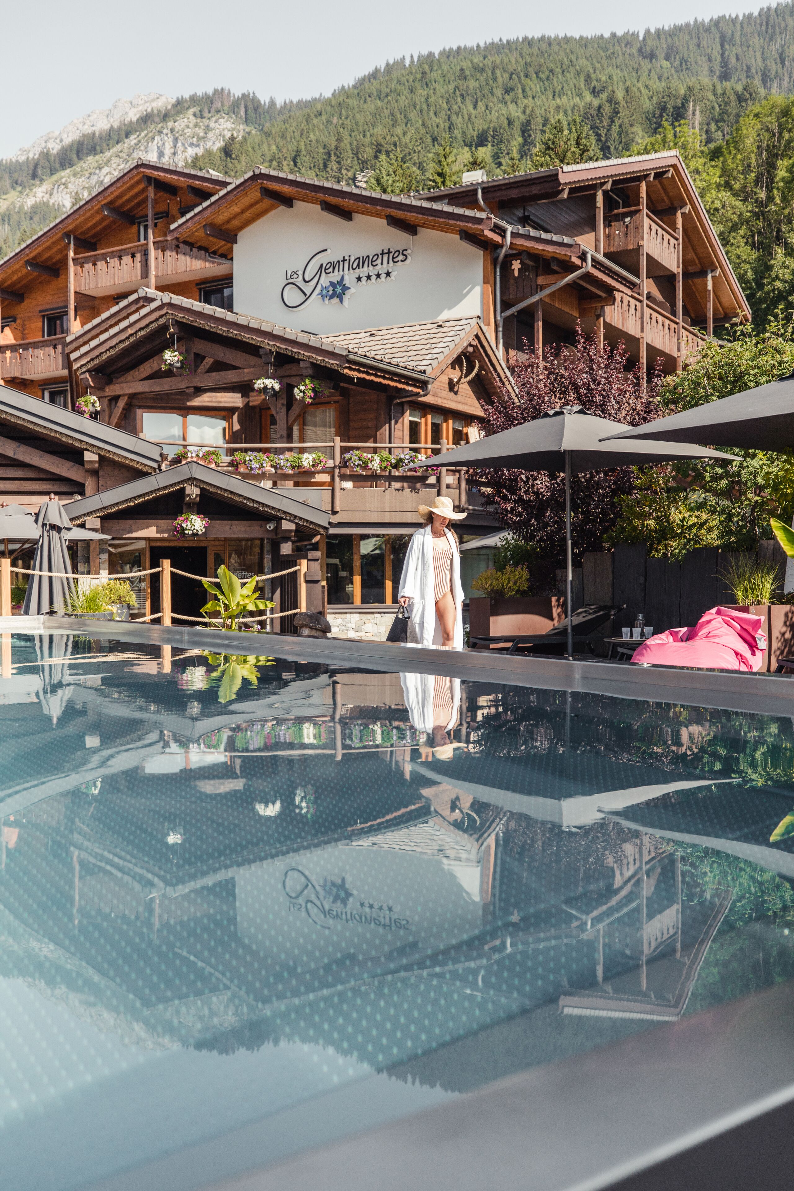 Un hôtel doté d’une piscine, d’une architecture en bois et situé dans un cadre montagneux.