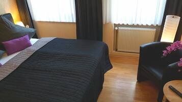 Ein Hotelzimmer mit Bett, Stuhl, Tisch und Heizkörper.