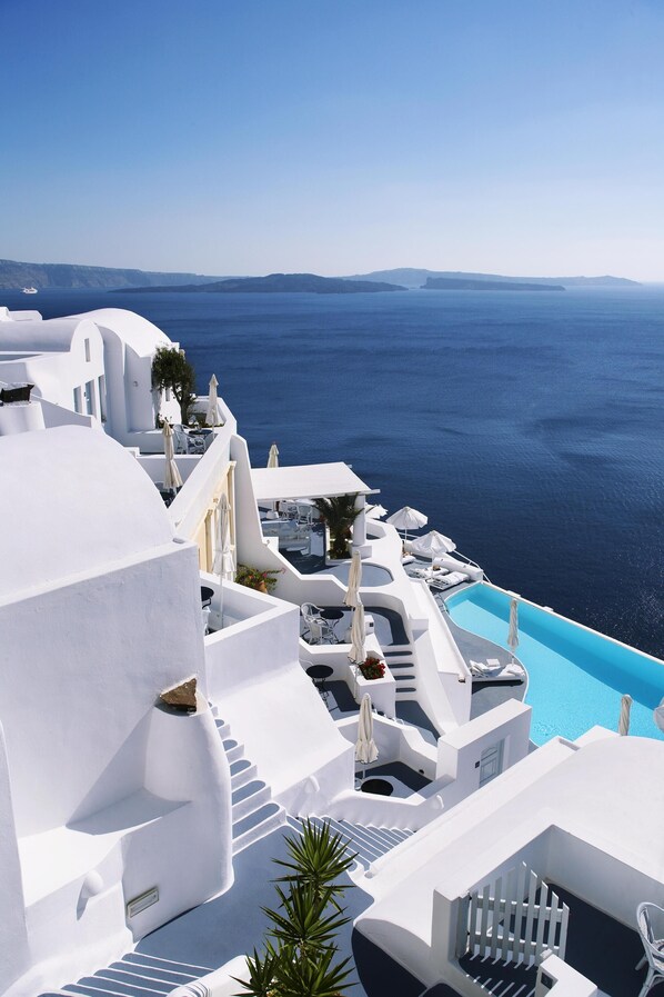 A white building with a pool and a view of the sea. - Katikies Santorini - The Leading Hotels of the world (Santorini)