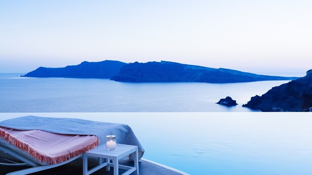 An infinity pool with a view of the sea and distant islands.