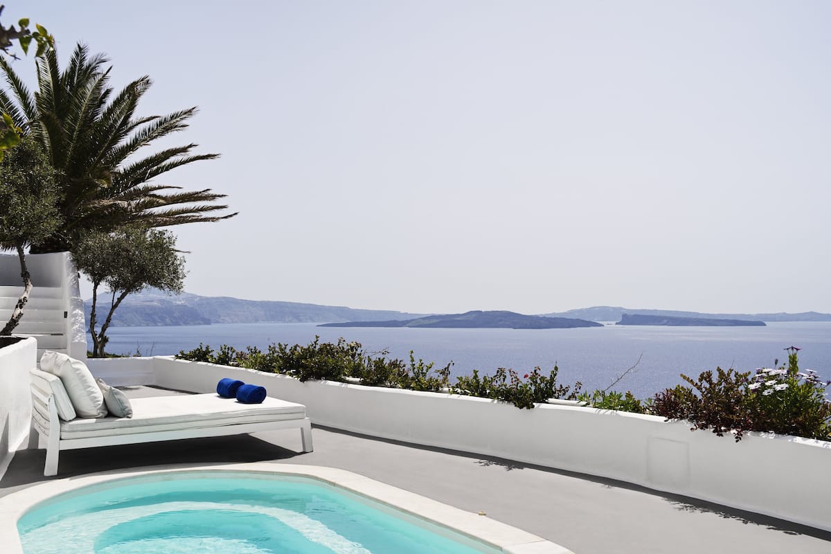 A pool area with a view of the sea and distant islands.