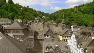 A historic town with traditional architecture, including half-timbered buildings and a church with a prominent tower.