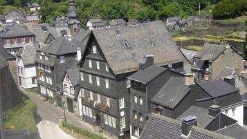 Eine historische Stadt mit traditionellen Fachwerkhäusern, einer markanten Kirche mit Turmspitze und einem Kopfsteinpflasterweg.