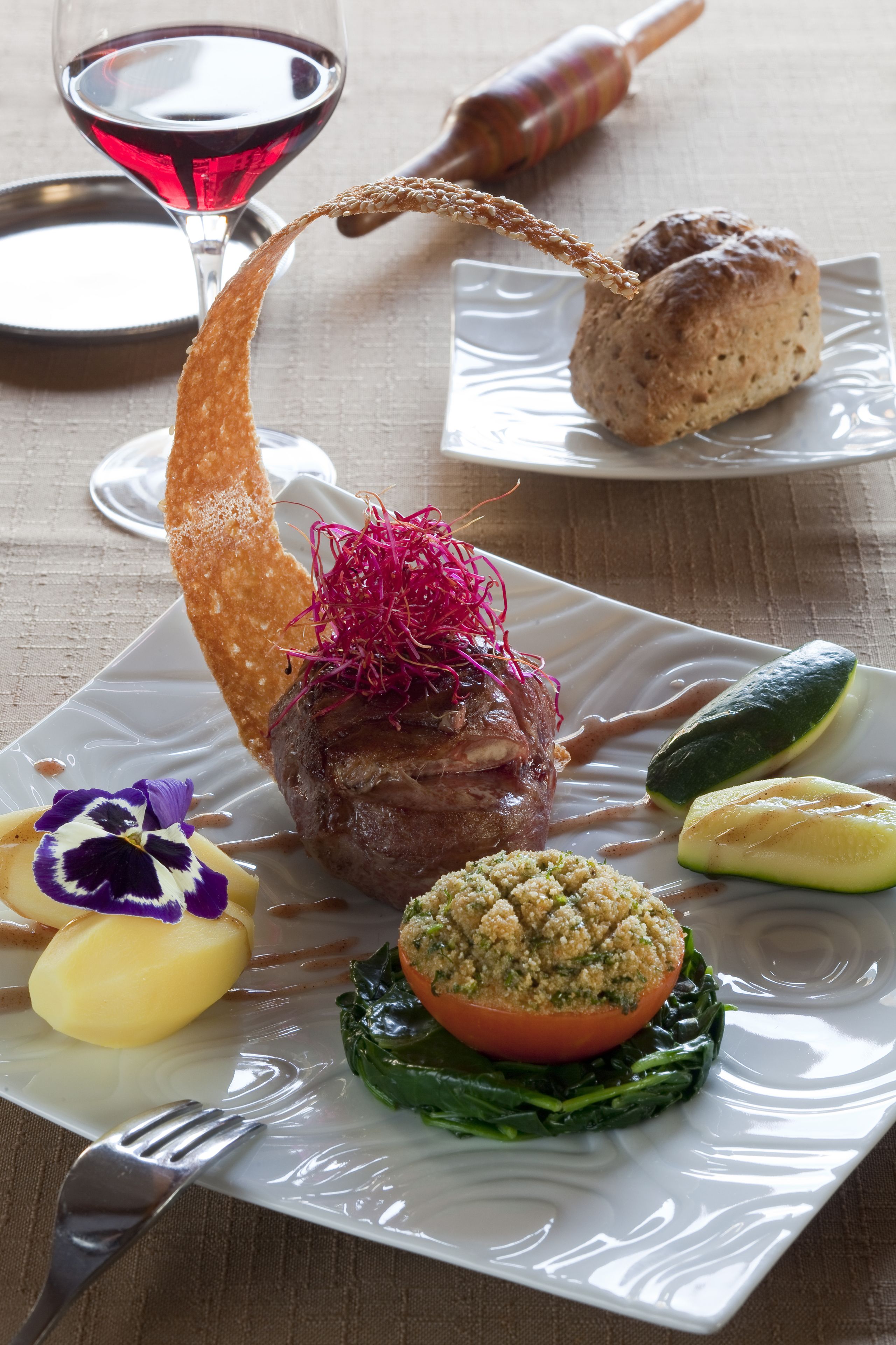 A plate of food with a variety of items including a meat dish, vegetables, and a dessert.