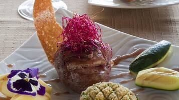 A plate of food with a variety of items including a meat dish, vegetables, and a dessert.
