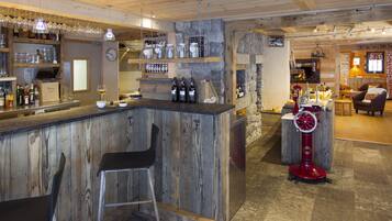 A rustic bar area with wooden bar counter, stools, and a red ice cream machine.
