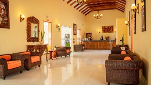 A spacious lobby with wicker sofas, a reception desk, and a high ceiling with wooden beams. - Hotel Agustos Urubamba (Urubamba)