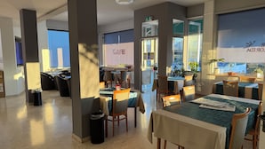 A restaurant with tables and chairs, a trash bin, and a view of the outside. - Hotel Florida (Piove di Sacco)