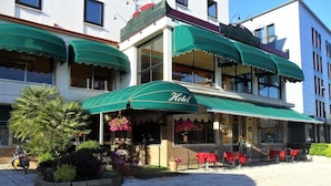A hotel with outdoor seating and a green awning. - Hotel Florida (Piove di Sacco)