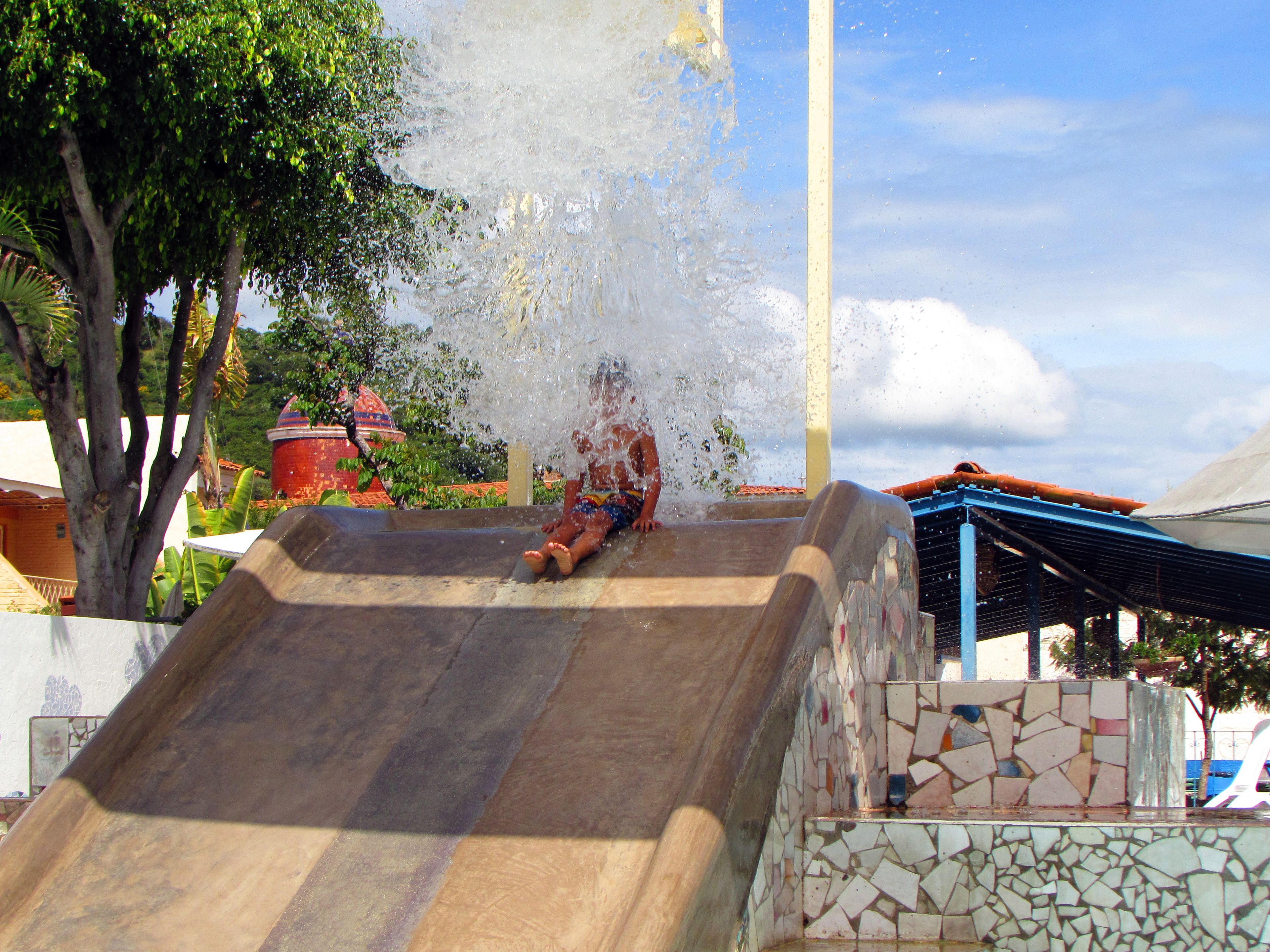 Un toboggan aquatique avec un mur recouvert de carreaux et une structure métallique.