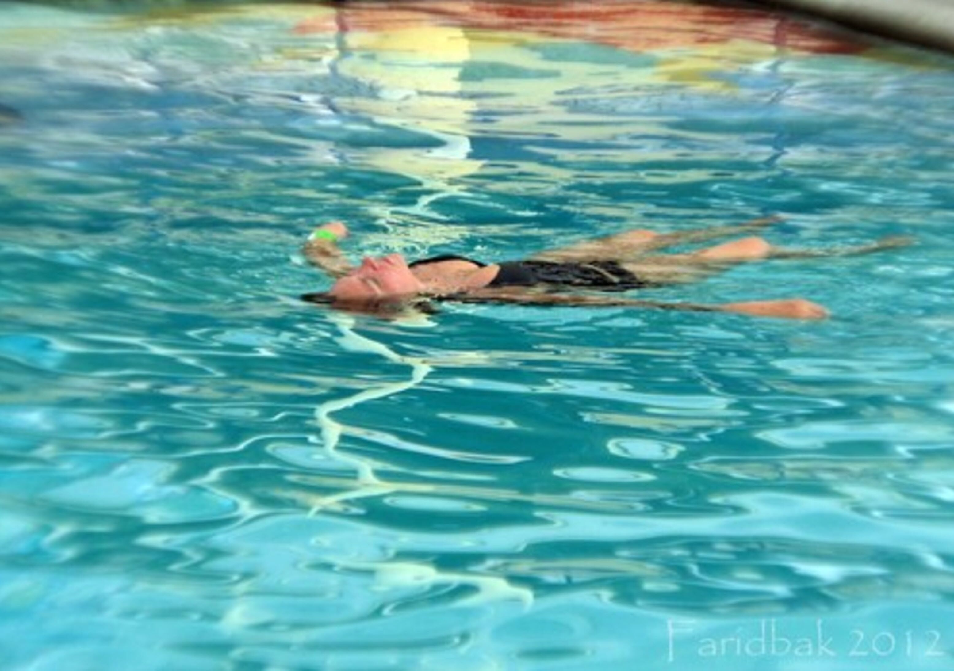Una persona nadando en una piscina.