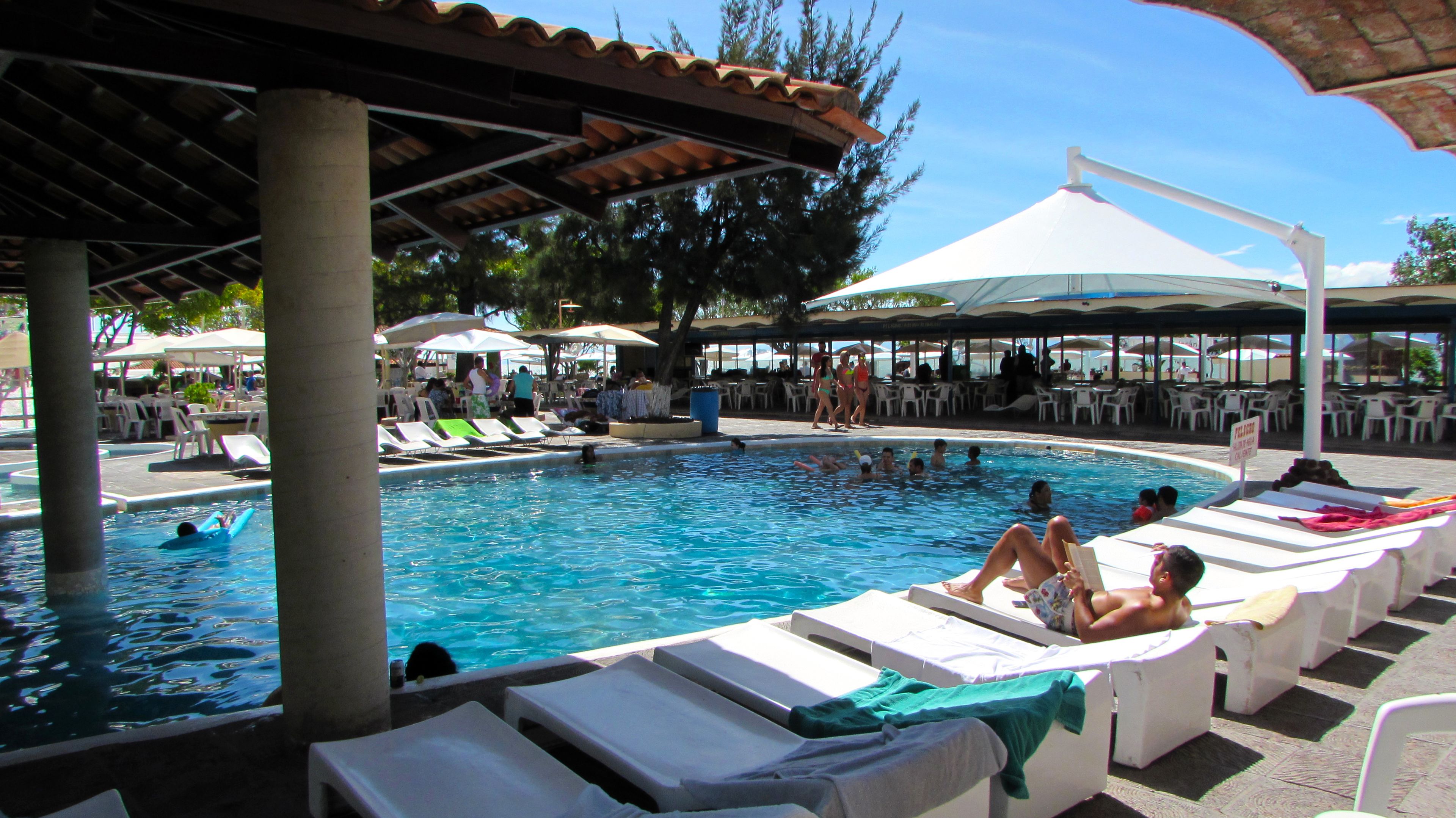 A pool area with lounge chairs and umbrellas.
