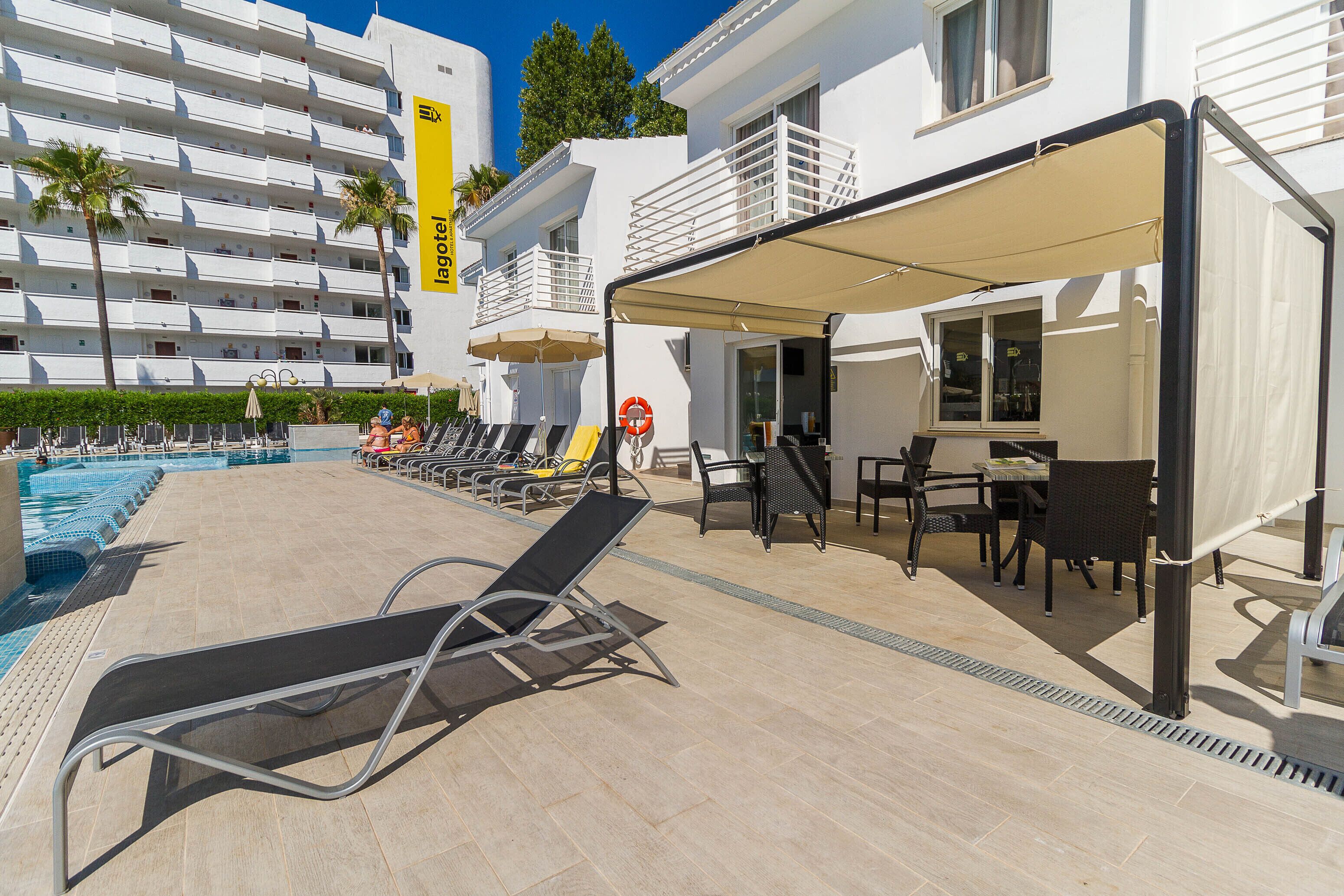 Un espace aménagé au bord de la piscine, avec des chaises longues, une table et des parasols.