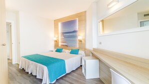 Una habitación de hotel moderna con una cama grande, un cabecero de madera y vistas al mar.