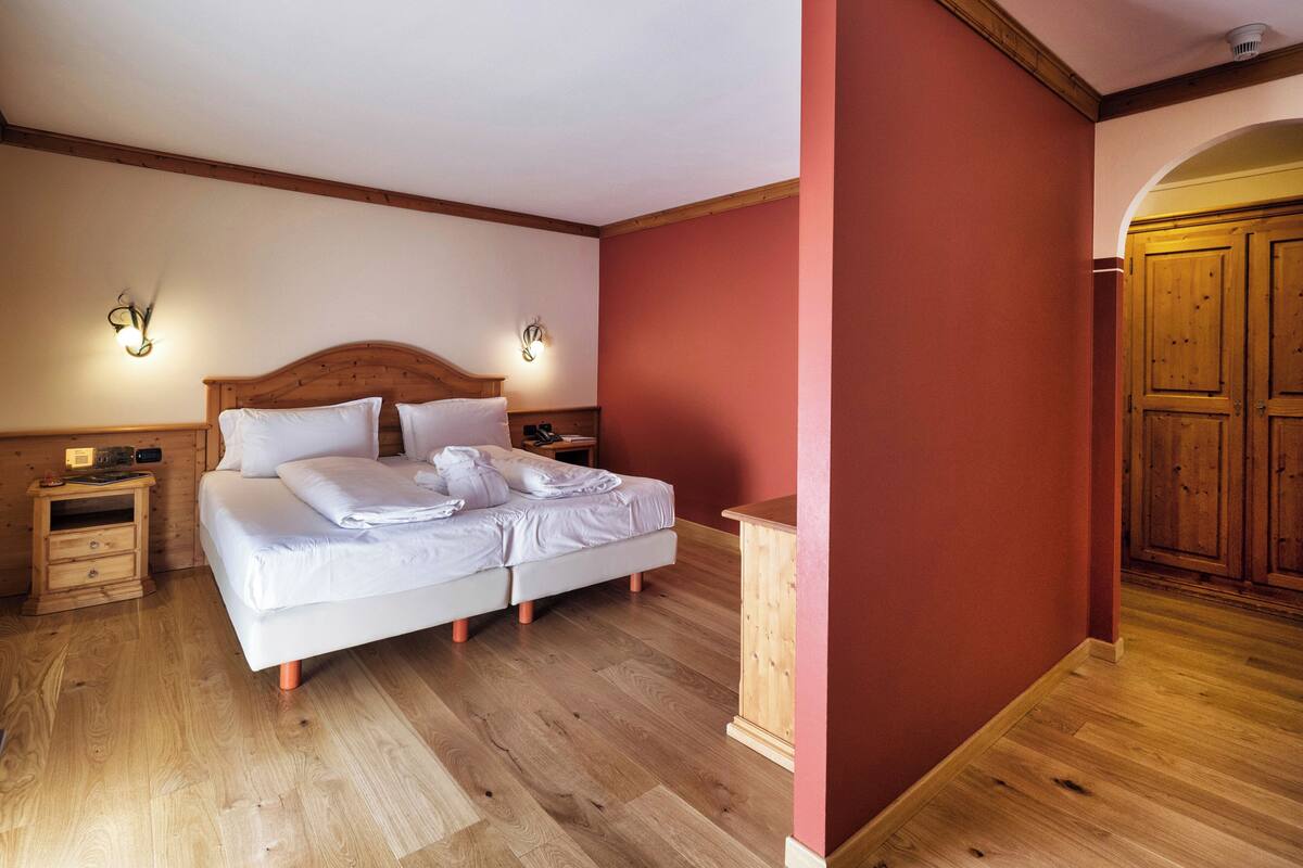 A bedroom with a wooden bed, two bedside tables, and a wardrobe.