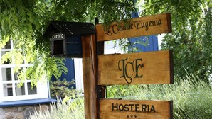 A wooden signpost with directional signs for 'Casa de Eugenia', 'ICE', and 'Hosteria', along with a mailbox labeled 'Correio'. - Hosteria La Casa de Eugenia (San Martín de los Andes)