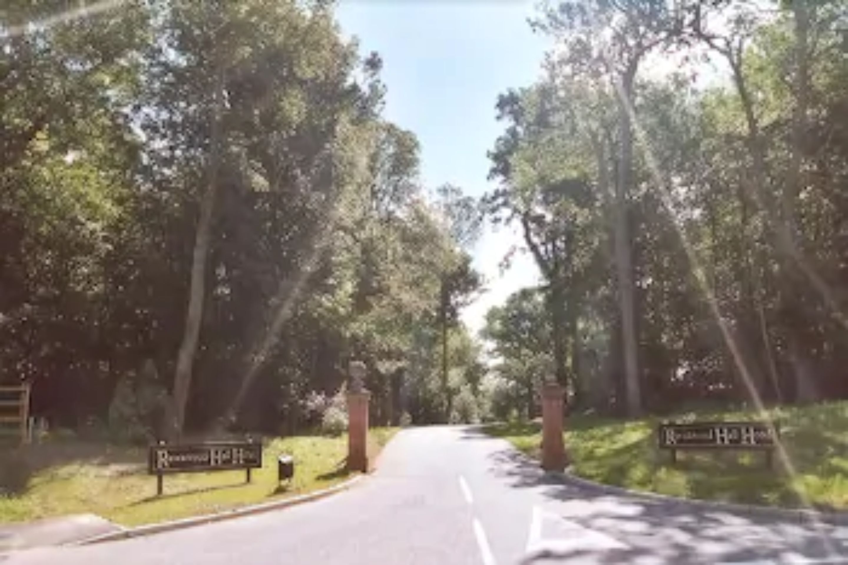 A road leading to a gated entrance with a sign that reads "Residential Hotel."